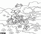 Fille à bicyclette dans le parc au printemps