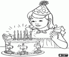Fille dans le moment de souffler les bougies de son gâteau d'anniversaire