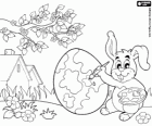 Tout prêt pour l'arrivée de Pâques, un lapin peint un oeuf de Pâques