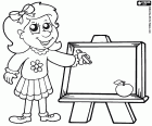 La petite fille avec un bâtonnet de craie dessine sur un petit tableau noir 